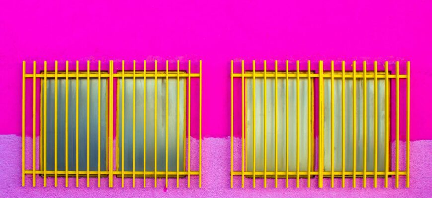 symmetric windows with grids on pink wall